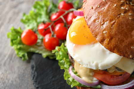 Tasty burger with fried egg on table, closeupの写真素材