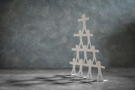 Pyramid made of paper people on grey background. Unity conceptの写真素材