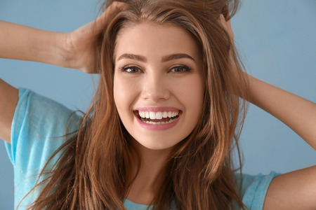 Portrait of beautiful smiling woman on color backgroundの写真素材