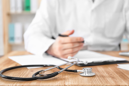 Stethoscope and blurred doctor on background. Health insuranceの写真素材