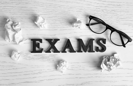 Word EXAMS made of letters on wooden backgroundの写真素材