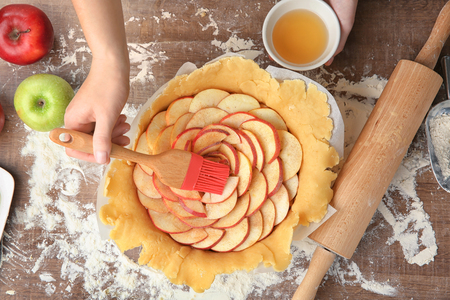 Woman preparing apple tart in kitchen, top viewの写真素材
