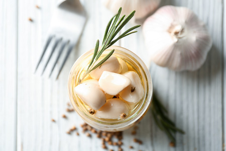 Preserved garlic in glass jar on tableの写真素材