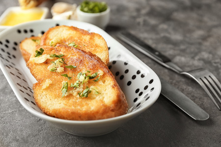 Plate with delicious homemade garlic bread on tableの写真素材