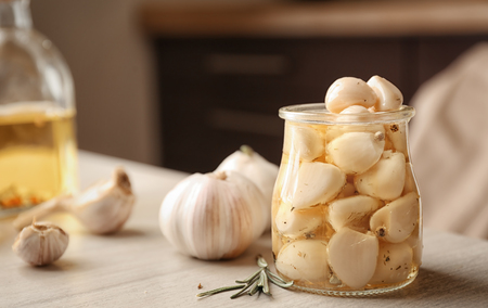 Preserved garlic in glass jar on tableの写真素材