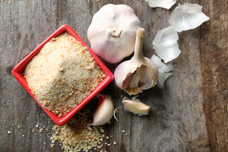 Bowl with dried garlic powder on wooden backgroundの写真素材