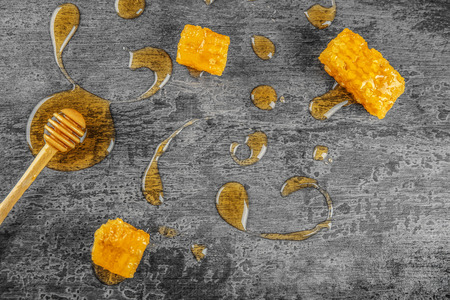 Composition with sweet honey, dipper and combs on grey backgroundの写真素材