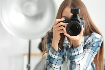Young female photographer working in studioの写真素材