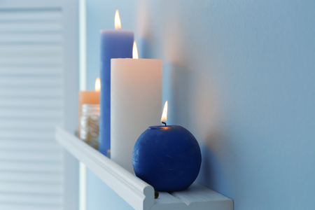 Beautiful burning candles on wall shelfの写真素材