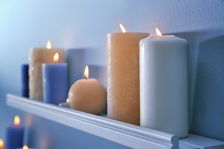 Beautiful burning candles on wall shelfの写真素材