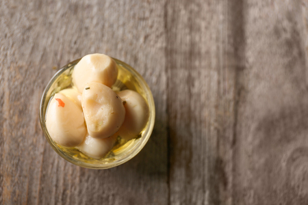 Preserved garlic in glass bowl on wooden backgroundの写真素材