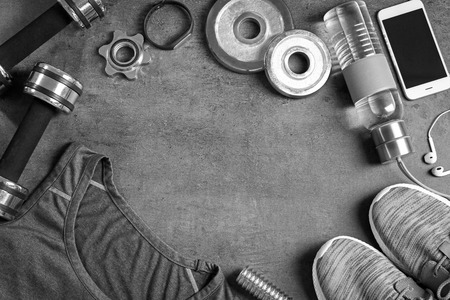 Gym stuff, mobile phone and blank space for exercise plan on grey background. Flat lay compositionの写真素材
