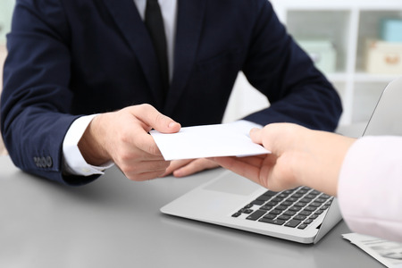 Businessman taking envelope with bribe from woman indoors, closeupの写真素材