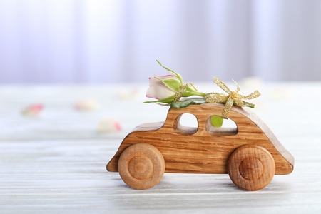 Decorative wooden car with beautiful rose on tableの写真素材