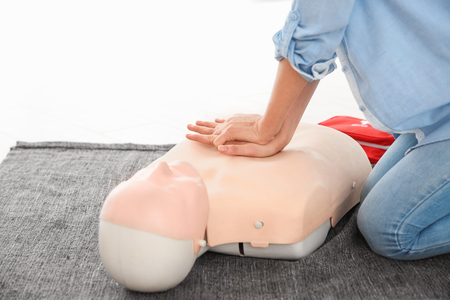 Woman practicing first aid on mannequin, closeupの写真素材