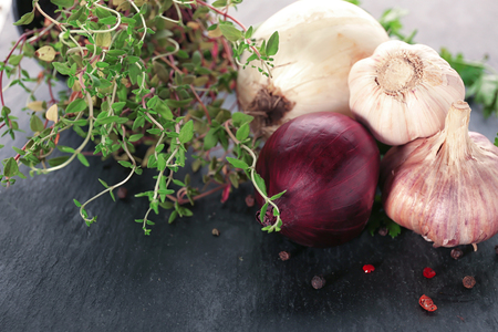 Fresh garlic, onion and herbs on dark backgroundの写真素材