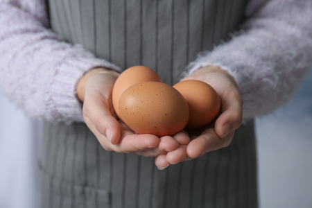 Woman holding chicken eggs, closeup