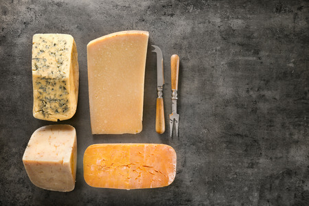 Different kinds of delicious cheese on grey background