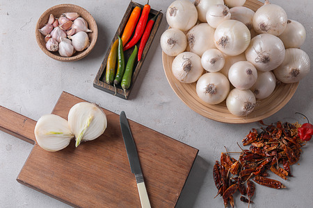 Composition with ripe onions and chili peppers on table