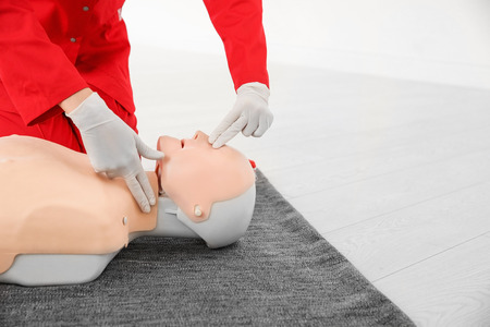 Woman practicing first aid on mannequin, closeupの写真素材