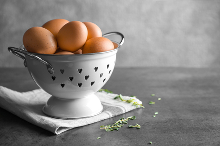 Chicken eggs in colander on tableの写真素材