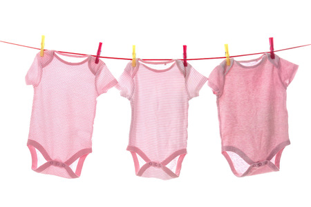 Children's clothes on laundry line against white backgroundの写真素材