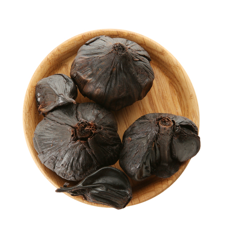 Plate with black garlic (Allium sativum) on white backgroundの写真素材