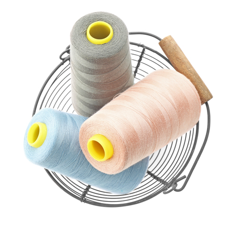 Metal basket with colorful sewing threads on white background