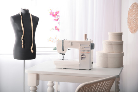 Sewing machine on table in tailor's workshop