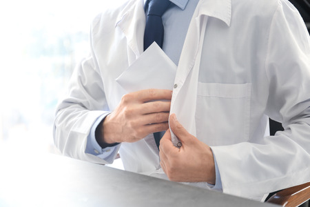Doctor taking bribe at his workplace, closeup