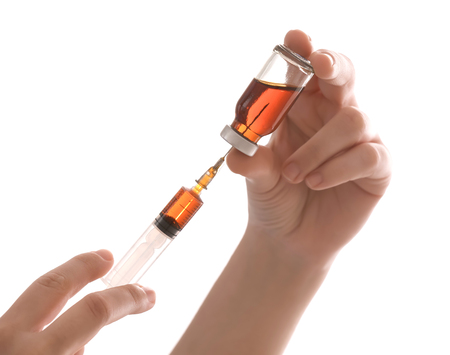 Doctor holding syringe and medicine for vaccination on white background, closeupの写真素材