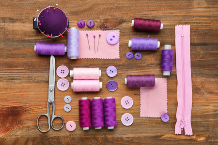 Colorful threads and sewing accessories on wooden backgroundの写真素材