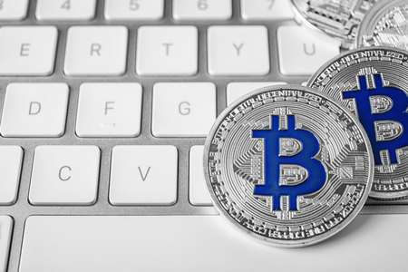 Silver bitcoins on computer keyboard