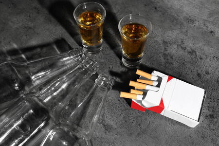 Alcohol and cigarettes on grey backgroundの写真素材