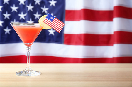 Glass of cocktail on table against flag of the USAの写真素材