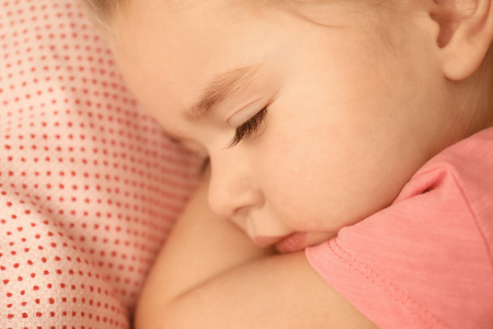 Cute little girl sleeping in bed at home, closeupの写真素材