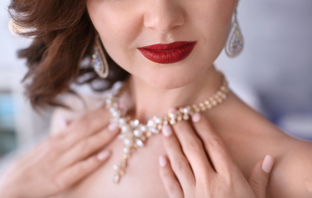 Beautiful woman with elegant jewelry on blurred background, closeupの写真素材