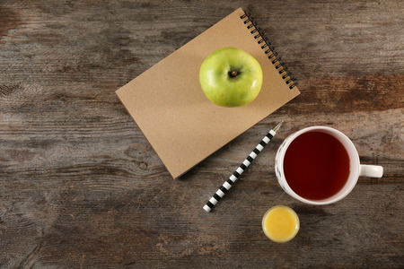 Cup of tea, apple and notebook on table, top view. Tasty breakfastの写真素材