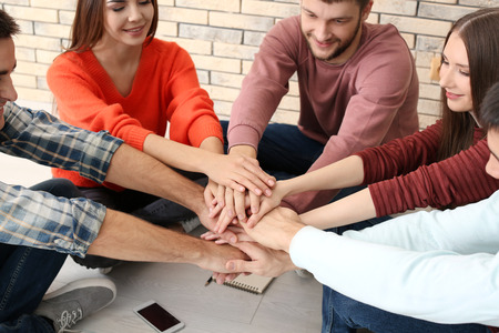 People putting hands together, indoors. Unity conceptの写真素材