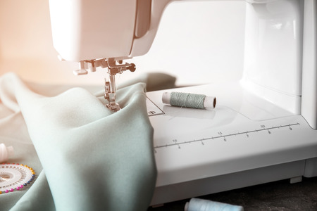 Modern sewing machine with fabric and threads, closeupの写真素材