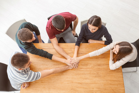 People holding hands together at table. Unity conceptの写真素材