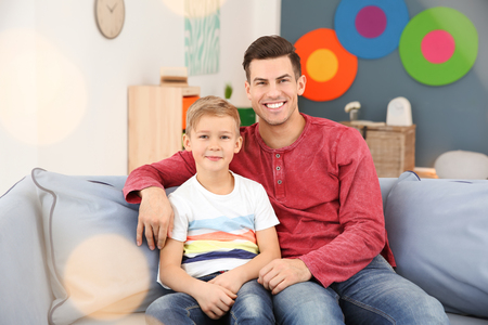 Young man and little boy indoors. Child adoptionの写真素材