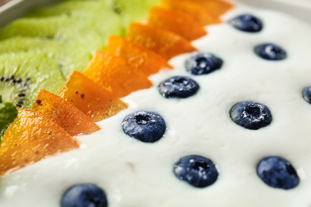 Yogurt with blueberry, date plum and kiwi, closeupの写真素材