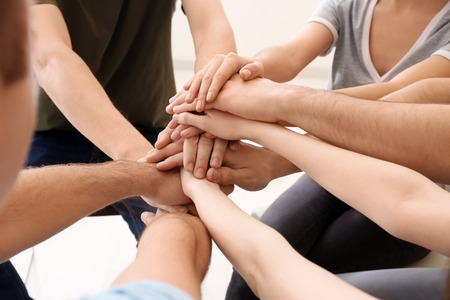 People putting hands together, closeup. Unity concept