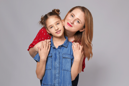 Portrait of happy mother and daughter on grey backgroundの写真素材