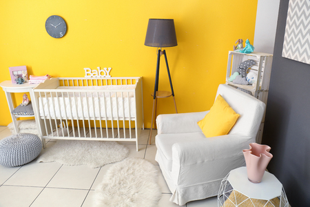 Children's room interior with crib and comfortable armchairの写真素材