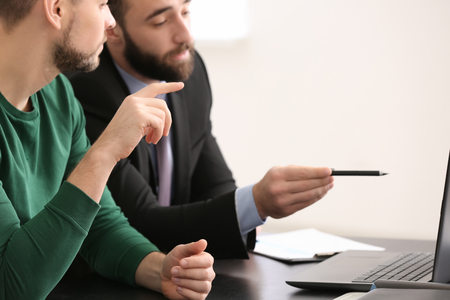 Businessman consulting young man in officeの写真素材