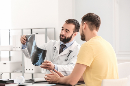 Doctor consulting male patient in clinicの写真素材