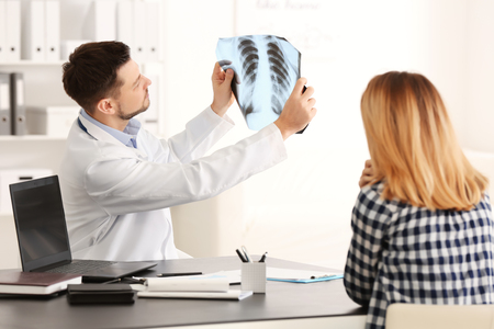 Doctor consulting female patient in clinicの写真素材