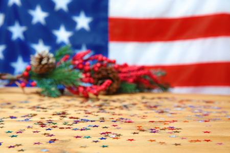 Confetti on wooden table against blurred American flagの写真素材